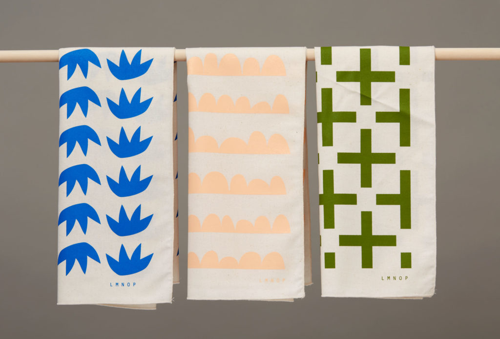 graphic tea towels hanging on a dowel