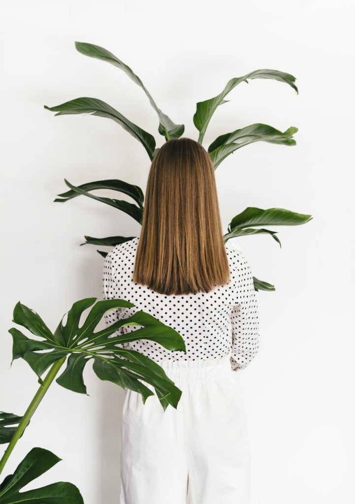 Woman from the back holding plant