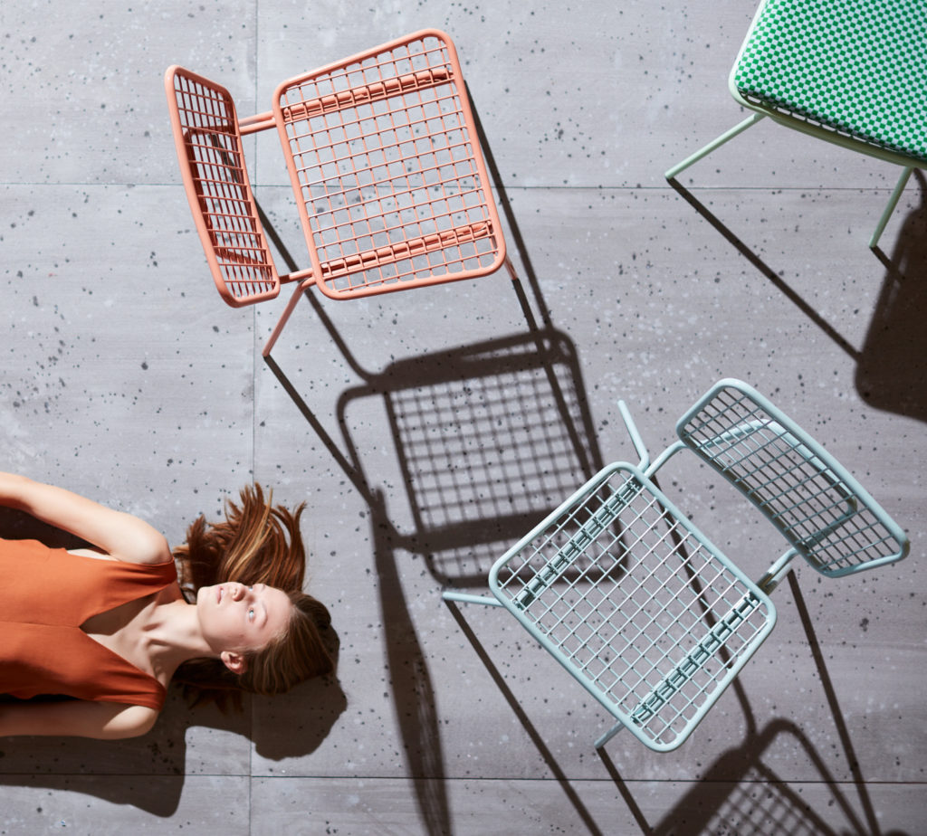 Outdoor furniture and woman lying on ground